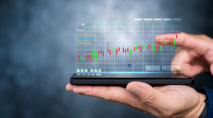 Trader use smartphone to analyzing growing stock on virtual screen for invest in trading.