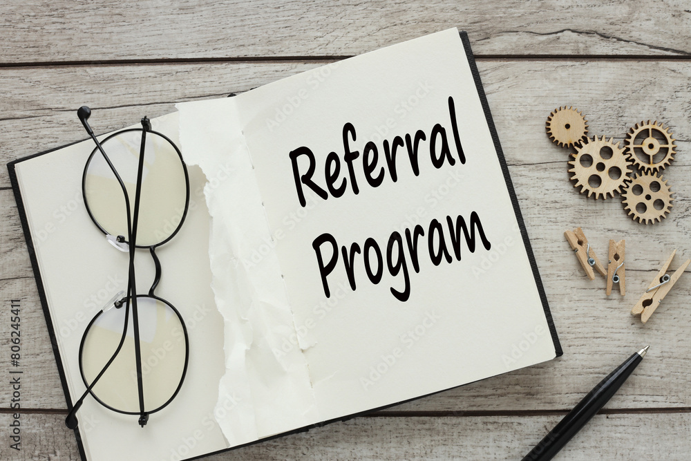 Poster glasses on an open notepad. text on page referral program. business concept.
