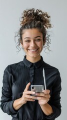 Fototapeta premium Smiling female entrepreneur holding smart phone and felt tip pen