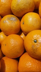 Close up pile of tasty fresh oranges sold at the market as a background.