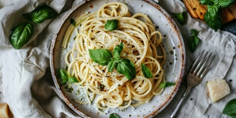 Plate of spaghetti with pesto sauce on a linen tablecloth