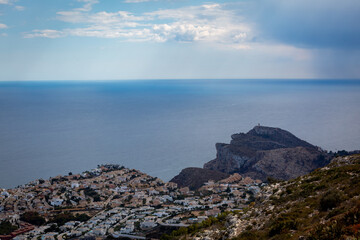 View from the top of the mountain Puig de la llorenca looking at Cala del moraig on a wet cloudy day whilst raining