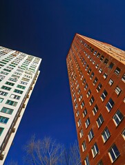 Two residential skyscrapers against a blue sky background.