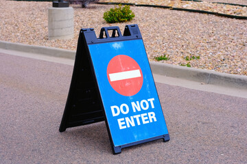 Do not enter stop sign on blue plastic portable folding sidewalk double sided sign stand on city...