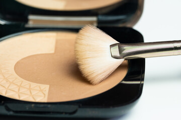 A small makeup kit with bronzing powders and a brush to apply them on the face