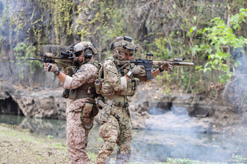 Soldiers  in camouflage military uniforms in shooting position ready for battle