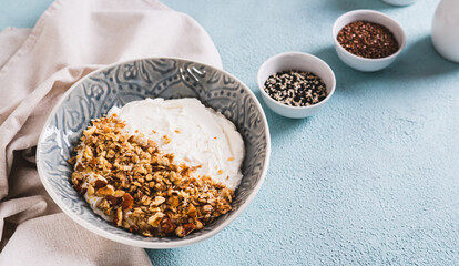 Bowl with yogurt, muesli and nuts for a healthy breakfast on the table web banner