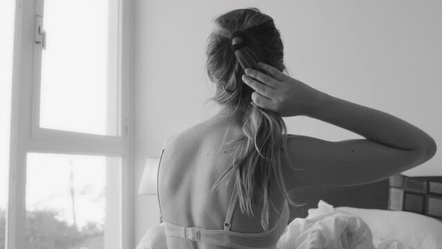 Woman in underwear sitting on hotel bed