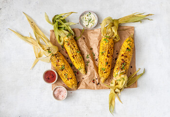 Grilled corn cobs with sauce, coriander and paprika