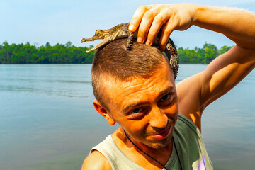 Man tourist with baby crocodile alligator Sri Lanka.