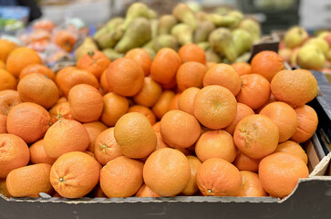 Box with ripe fresh organic tangerines on the shelf of a fruit supermarket are displayed for sale....