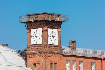 clock on the tower of a brick building showing five minutes to three o'clock in the afternoon