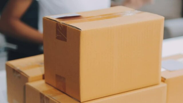 Startup small business entrepreneur of freelance Asian woman using a laptop with box Cheerful success online marketing packaging box and delivery SME idea concept