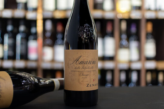 Bottle of Italian red dry wine Zenato Amarone Valpolicella Classico 2018 close-up on blurred background of wine shelves. Ukraine, Zhytomyr, April, 25, 2024