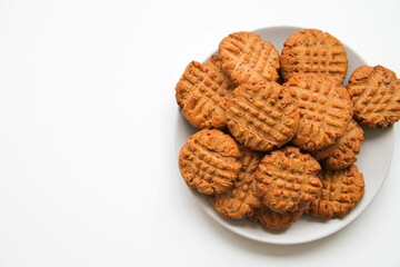 Stack of freshly baked peanut butter cookies on a light plate. White background. Copy space, place for your text.