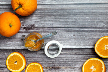 Tasty and healthy homemade orange marmalade. Top view of a table with a jar of homemade orange...