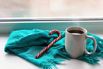 A mug of hot coffee is on the windowsill.