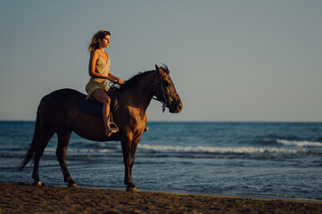Beautiful woman enjoying summer on a beach with her rearing stallion