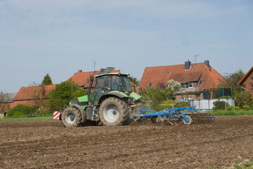 Obraz premium Landwirt beim Grubbern eines Feldes