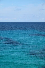 Türkisblaues Wasser am Mittelmeer mit Sand und Korallen vor Blauem Himmel an einem Sonnentag...