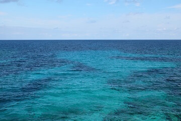 Türkisblaues Wasser am Mittelmeer mit Sand und Korallen vor Blauem Himmel an einem Sonnentag Querformat