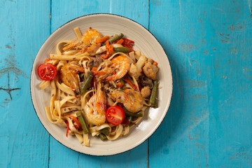 shrimp and udon vegetables pad thai sauce and chopsticks for and on the table