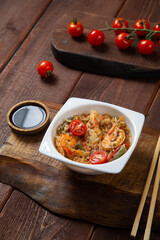shrimp and rice yaki soba sauce next to cherry tomatoes soy sauce and chopsticks