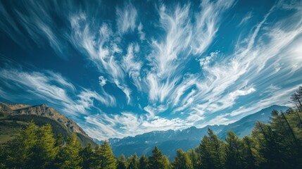 a sky captured by dramatic cloud formations over a serene forest and mountain landscape