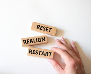 Reset Realign Restart symbol. Concept words Reset Realign Restart on wooden blocks. Businessman hand. Beautiful white background. Business and Reset Realign Restart concept. Copy space.