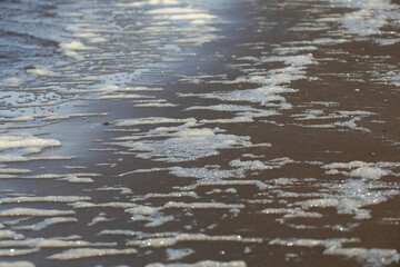 Foam on the sand from the wave, North sea coastline