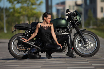 Portrait of young woman on a black motorcycle