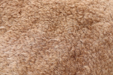 Closeup of a rich brown wool carpet with a textured pattern resembling fur