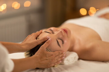 A calming scene at a spa with a young blonde woman receiving a delicate facial massage, showcasing...