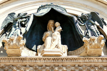 Statue de la Vierge Marie avec l’Enfant Jésus ornant le tympan de la porte centrale de la...