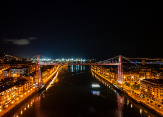 Fototapeta premium Vizcaya Hanging Bridge (Puente Vizcaya) over Nervion River in Bilbao, Spain, Night Aerial View