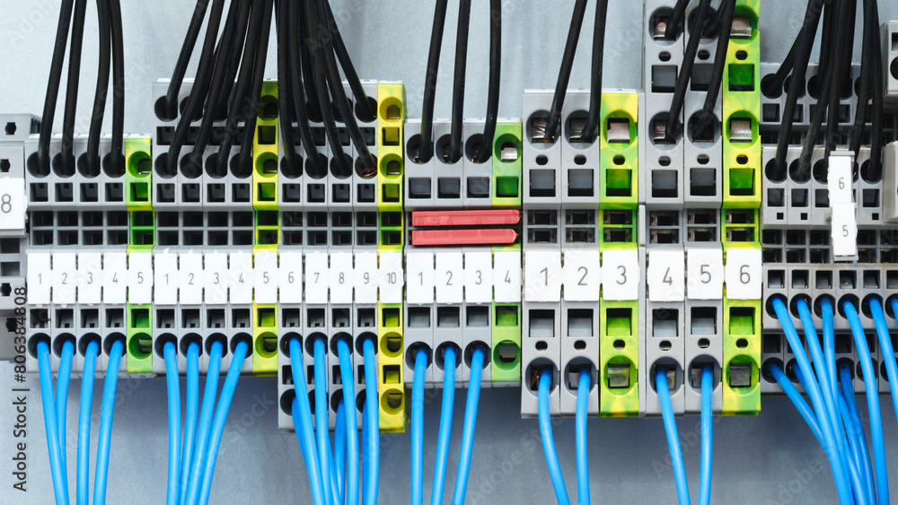 Poster a bunch of wires are connected to a box with yellow and black labels