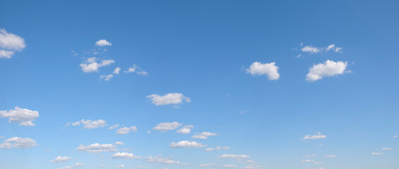 The sky is blue with a few clouds scattered throughout. The clouds are white and fluffy, giving the...