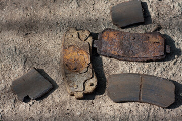 Close up of uneven car brake pad wear. Old rusty car brake system parts
