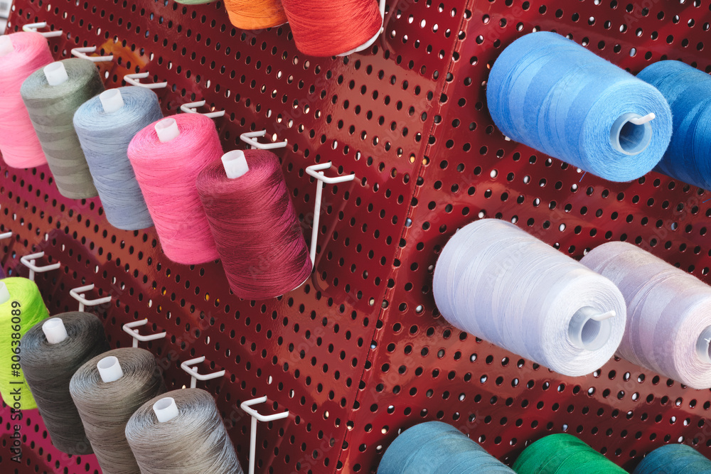 Aufkleber a rack of colorful spools of thread. the spools are of various colors and sizes. the spools are arra