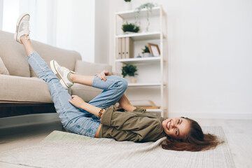 Cosy, Relaxing Apartment: A Happy Woman Lying on a Modern Sofa in a Peaceful Living Room.