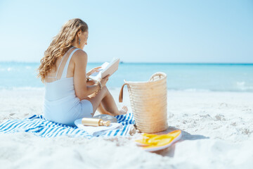 relaxed elegant woman on beach with straw bag