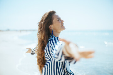 smiling modern woman on beach rejoicing