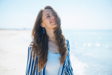 happy stylish woman on seacoast enjoying peace of mind