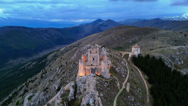 Rocca Calascio castle with lights in Abruzzo, Italy with the Church of the Madonna della Pieta