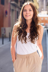 Fototapeta premium Young cheerful woman walking in historic city center