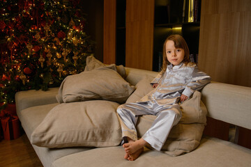 Fototapeta premium A happy family poses in pajamas in New Year's locations.