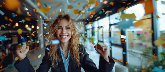 Fototapeta premium A cheerful businesswoman celebrating with raised fists, a winning attitude, streamers, colorful background, office environment.