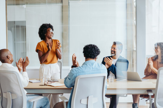Successful business meeting with a creative team applauding their colleagues' project