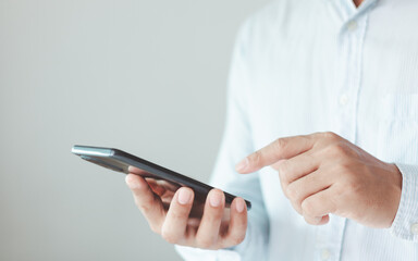 Close up of businessman using mobile smart phone isolated on white background. searching data networks or chatting online. typing sending message. mockup mobile phone wireless technology.
