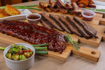 A serving table of barbecue ribs and sliced brisket
